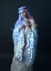 artistic portrait of beautiful female model with long purple hair wearing a fantasy fairy crown,...