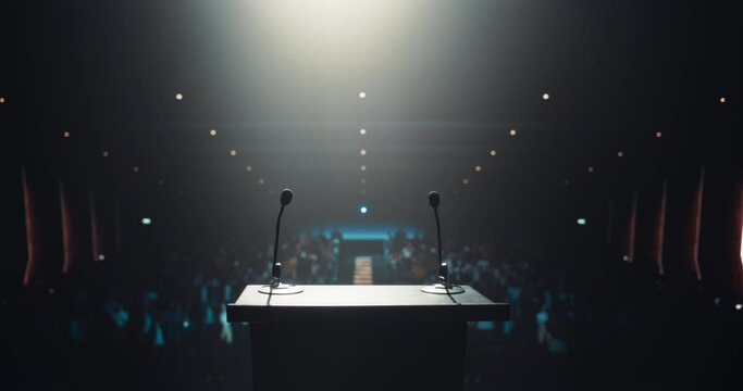 Modern Conference Stage With Two Microphones Under Spotlight, Ready for a Speaker to Come Up on Stage in a Dark Lit Auditorium. Public Speaking and Conference Presentation Concept