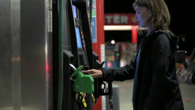 a woman at a gas station presses a pin code at pay machine, wants to pay