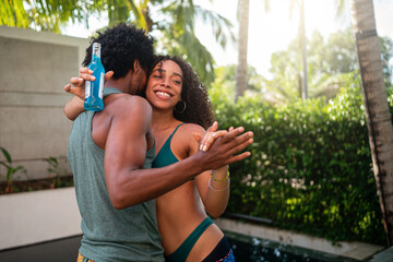Beautiful African - American woman dancing with a man, outdoors in a tropical natural environment. 