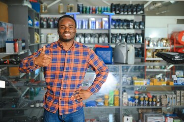 Portrait of a handsome salesman in an auto parts store. The concept of car repair