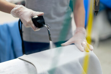 close up professional dry cleaning young girl bleaches stain on a white jacket professional...