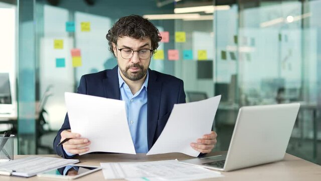 A thoughtful professional reviewing insurance paperwork at a clean desk