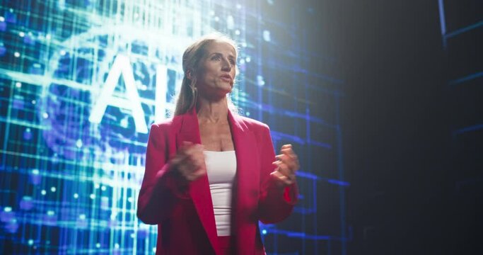Female Public Speaker Delivering a Motivational Speech at a Tech Startup Seminar to Help Entrepreneurs Embrace Artificial Intelligence. Keynote Slide with an Animated Brain and Words AI on Big Screen