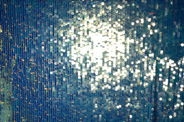 a wallpaper of glittering blue sequin background with golden disco spotlight