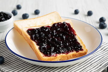 Homemade Blueberry Jam and Toast on a Plate, side view.