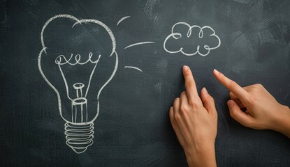Hand pointing to a light bulb and a thought bubble drawn on the blackboard, concept of idea, creativity, business.