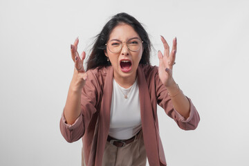 Irritated Asian woman in glasses expressing annoyed, mad, frustrated feelings isolated over white...