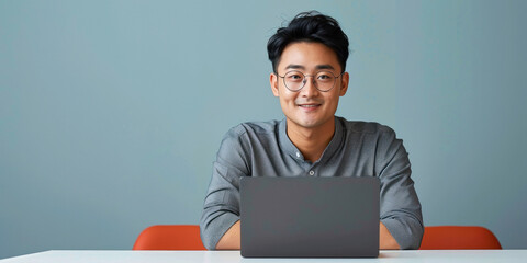 young Chinese man using laptop - Powered by Adobe