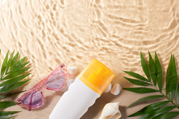 Sunscreen bottle with sunglasses on a sandy beach, decorated with palm leaves and seashells. Ideal for advertising sunscreen products and beach accessories for summer vacations