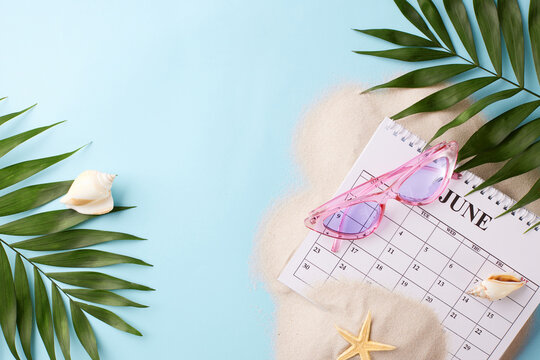 Flat lay featuring June calendar with beach accessories on a sandy background, suitable for articles about summer planning - Powered by Adobe
