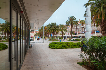 A view from under the modern, glass building to the old town in the City of Split and sidewalk...