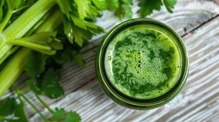 Obraz premium a green juice with celery in a glass jar on a wooden table, closeup. The green juice is in a smoothie in a glass jar placed on a wooden table. 