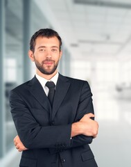 Smiling professional business man standing in office