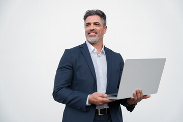 Middle age mature businessman using pc laptop for business work application. Smiling handsome older man in formal suit holding computer gadget, looking aside. Isolated white background with copy space