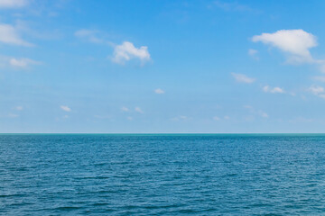 Obraz premium Blue sky with white clouds and the ocean deep indigo in daylight.