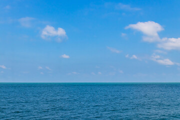 Obraz premium Blue sky with white clouds and the ocean deep indigo in daylight.