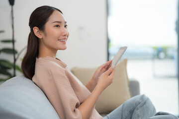 Smiling young woman using tablet at home