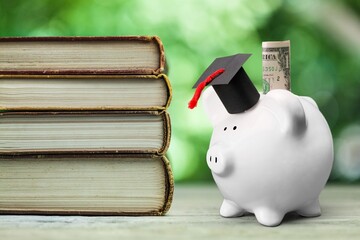 Graduation hat on piggy bank with set of books