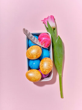 Top view layout with colored easter eggs on pink background