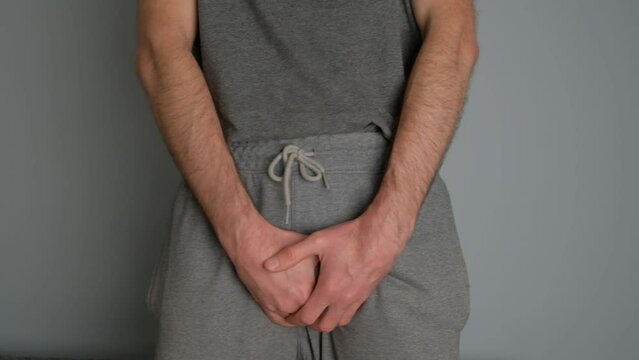 A man with prostate disease holds his hands in the groin area.