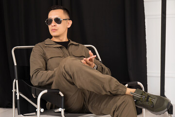 Portrait of a man in sunglasses sitting on a chair