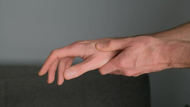 Acupressure, hand self-treatment, acupressure on a gray background close-up.