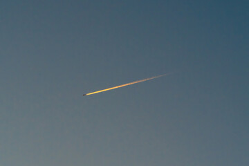 夕暮れの空に浮かぶ飛行機雲