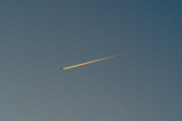 夕暮れの空に浮かぶ飛行機雲