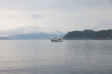 Boat floating on misty British Columbia waters