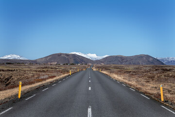 empty road to snowcapped mountains