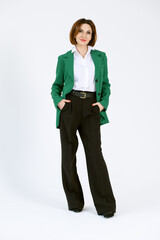 Portrait of a confident business woman in a green jacket on a white background. Full-length portrait of a middle-aged woman in black trousers