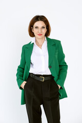 Portrait of a confident business woman in a green jacket on a white background. A middle-aged woman looks at the camera.