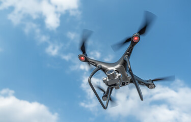 A black modern drone with a camera flies in the sky.