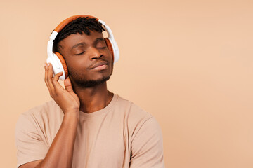 Smiling african american man wearing wireless headphones listening to music
