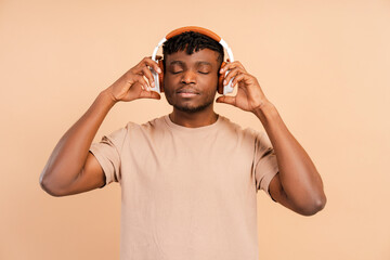 Closeup, handsome african american man listening to music in wireless headphones with closed eyes