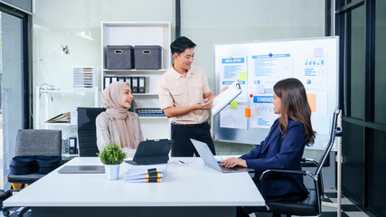 Comprehensive financial chart adorns the whiteboard during a presentation, where male and female...