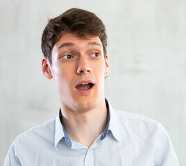 Obraz premium Emotions, people and positive concept man expresses different on gray background