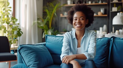 Obraz premium Casual Elegance: Smiling Woman in Business Attire on Blue Sofa