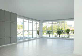 Empty room with large windows and laminated floor