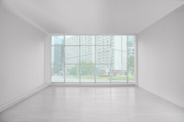 Empty room with large window and laminated floor
