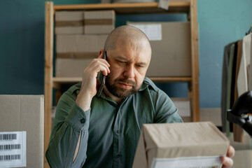 The manager talks to the client on the phone and clarifies the parcel delivery address. Small...