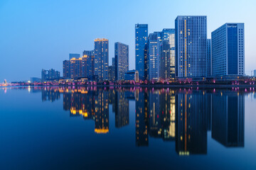 Skyscrapers reflection upon a river in evening, just after sunset, in Tongzhou District, Beijing, China