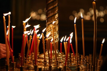 A person lighting a candle in a church, suitable for religious and spiritual concepts