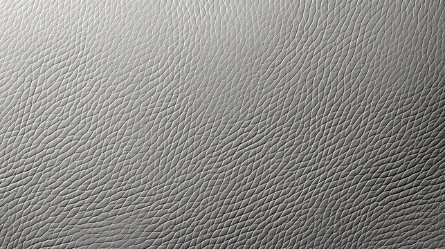 A close-up view of a grey leather surface showcasing its detailed texture and grain. The image highlights the material's natural patterns and tactile quality, ideal for background or design use