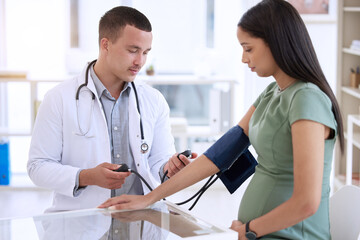 Doctor, man and pregnant woman in clinic for blood pressure, healthcare checkup and consultation. Male medical expert, pregnancy and patient with hypertension in office for preeclampsia and wellness