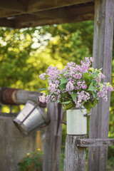 Still-life. Photo of a bouquet of lilacs near an old well.