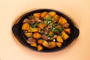 Fried potatoes with meat in a frying pan.