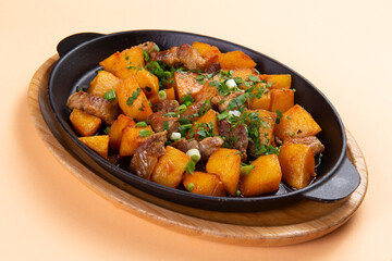 Fried potatoes with meat in a frying pan.