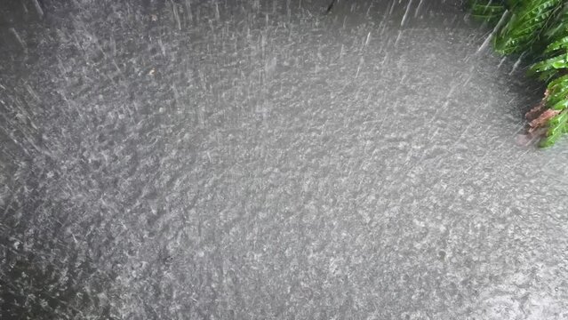 A strong storm outside. Top view of a shower with hail. Raindrops make circles, Rain falling on the water surface  top view